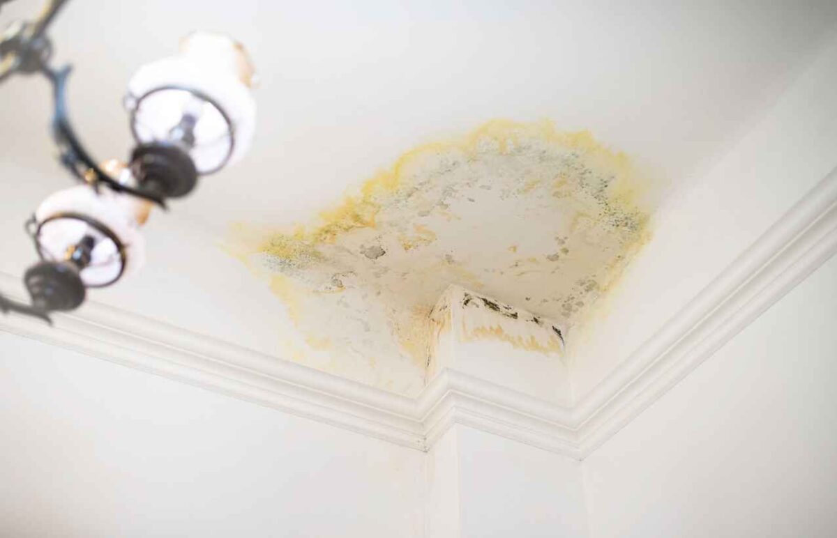 A stain on the ceiling in the apartment from flooding by the upstairs neighbors. Water leak damage.